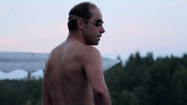 Mann macht sich bereit zum Schwimmen im See — Stockvideo