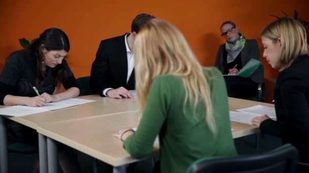 Jóvenes empleados de negocios resolviendo hojas para reuniones — Vídeo de stock