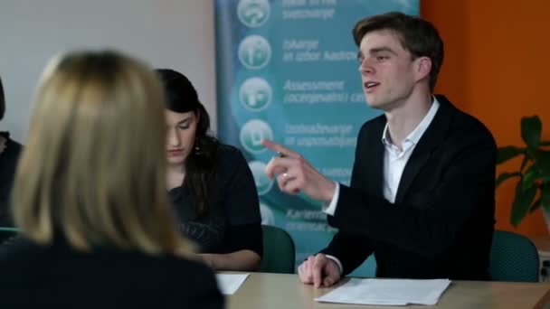 Jóvenes empleados de negocios resolviendo hojas para reuniones — Vídeo de stock