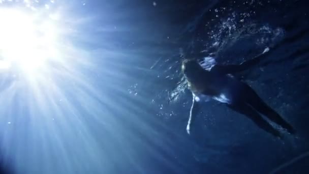 Joven, hermosa mujer en ropa nadando bajo el agua — Vídeo de stock