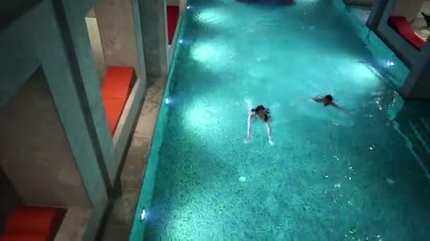 Молодая пара в большом бассейне — стоковое видео