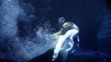 vrouw in kleren zwemmen onder water