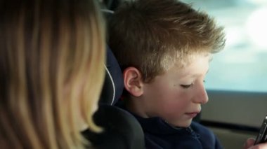 çocuklar aile konuma seyahat ederken cep telefonu ile oynarken arabanın arkasında