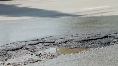 Asfalt yol ve araba sürücüleri üzerinde üzerinde büyük delik