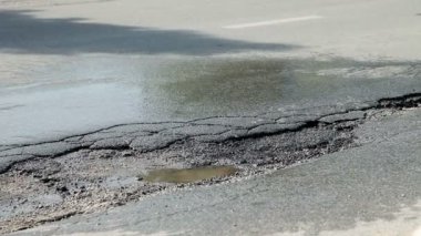 Asfalt yol ve araba sürücüleri üzerinde üzerinde büyük delik