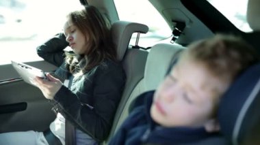 Aile tatil için seyahat ederken tablet pc ile oynayan genç kız