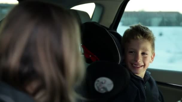 Bruder und Schwester auf dem Rücksitz des Autos haben Spaß — Stockvideo