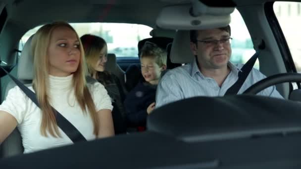 Niños en la parte trasera del coche divirtiéndose mientras los padres conducen el coche — Vídeo de stock