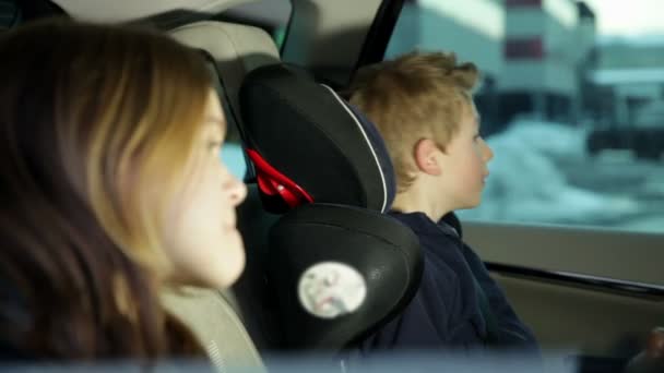 Hermano y hermana sorprendidos por algo mientras la familia conduce en coche — Vídeos de Stock