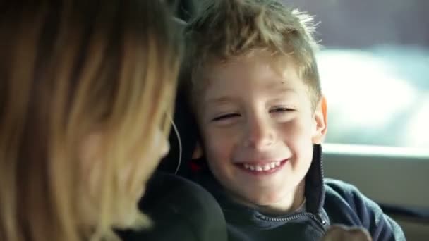 Jeune frère taquine soeur en voiture tandis que la famille voyage — Video