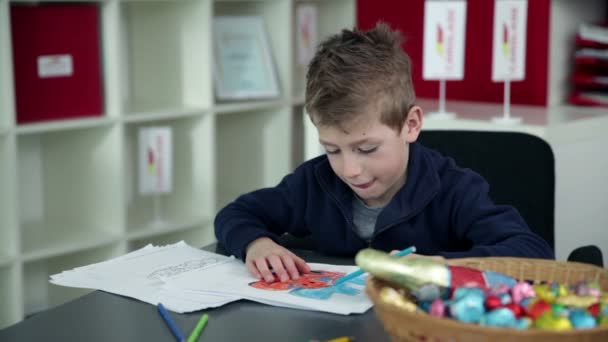 Young boy drawing in kindergarten — Stock Video