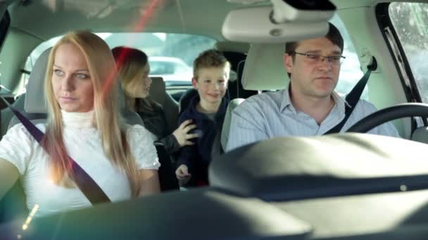 Niños en la parte trasera del coche divirtiéndose mientras los padres conducen el coche — Vídeo de stock