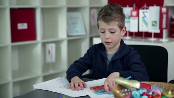 Young boy drawing in kindergarten — Stock Video