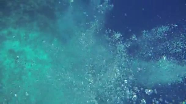 Bubbles of air in deep blue sea with people diving — Stock Video