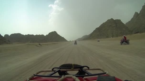 Conducir a través del desierto con quadro motocicleta en tiempo nublado — Vídeos de Stock