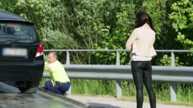 kadın geçen sürücü tarafından yardım ediliyor ve kırık araba yükleme araba yardım