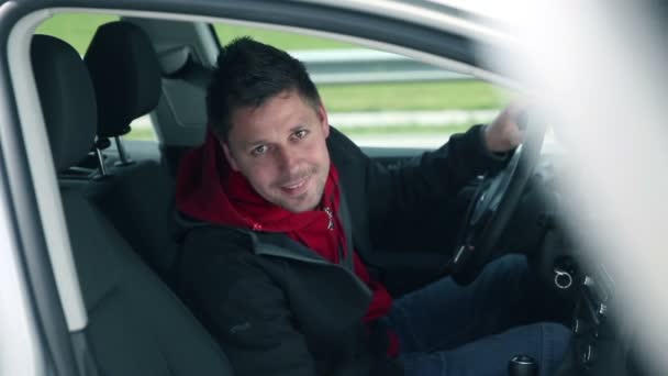 Hombre sonriendo en coche invitando a una mujer a sentarse — Vídeo de stock