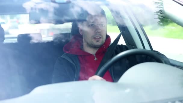 Mann fährt Auto und spricht Beifahrer an — Stockvideo