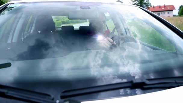 Άνθρωπος οδήγηση αυτοκινήτου με cloudscape στον ανεμοφράκτη — Αρχείο Βίντεο
