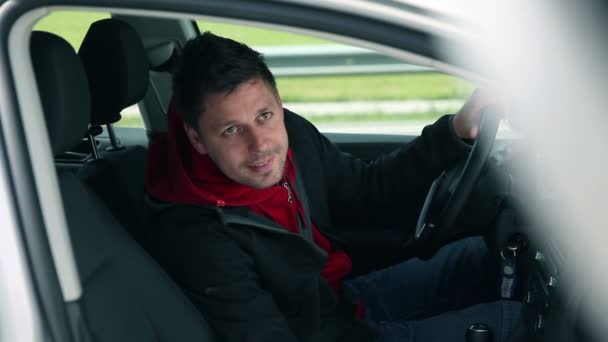 Hombre sonriendo en coche invitando a una mujer a sentarse — Vídeos de Stock