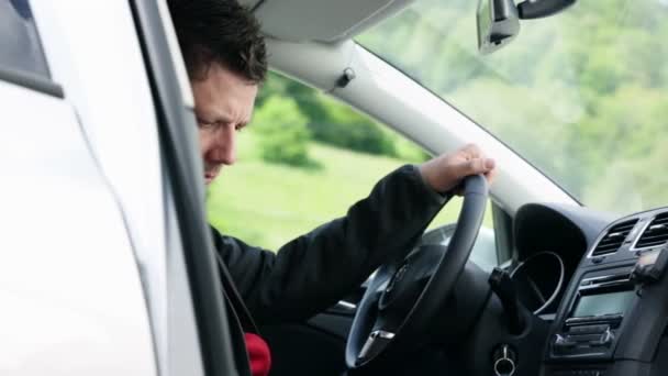 Человек в машине проверяет мобильный телефон — стоковое видео