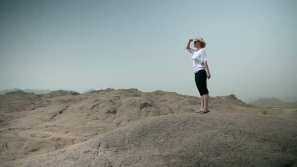 Mujer rubia joven mirando alrededor en rocoso Safari — Vídeos de Stock