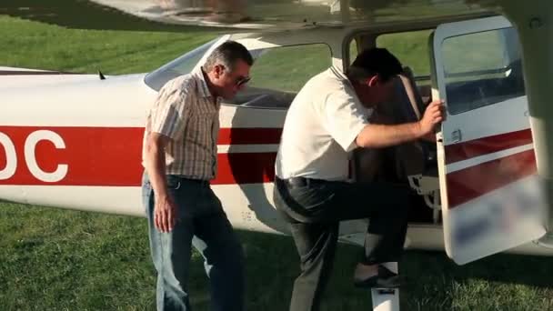 Close up of two man going in to small airplane — Stock Video