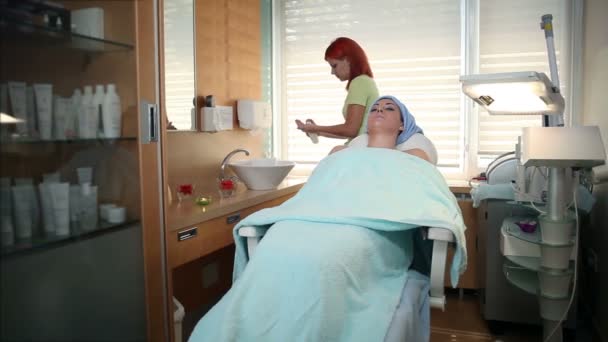 Γυναίκα θεραπευτής προσθήκη κρέμα στο δέρμα του προσώπου — Αρχείο Βίντεο