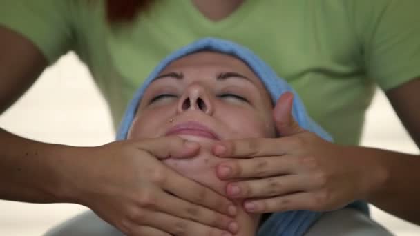 お客様の顔の皮膚をマッサージ女性セラピストのクローズ アップ — ストック動画
