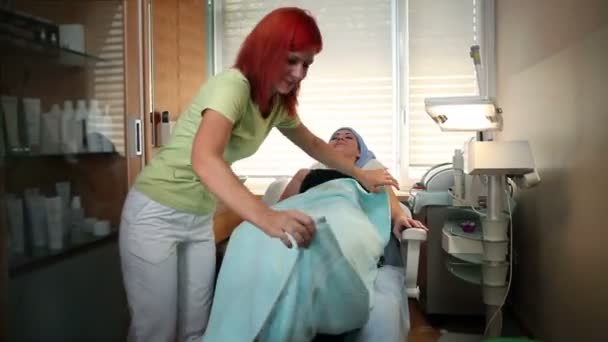 Κόκκινα μαλλιά γυναίκα προετοιμασία πελάτη για μασάζ — Αρχείο Βίντεο