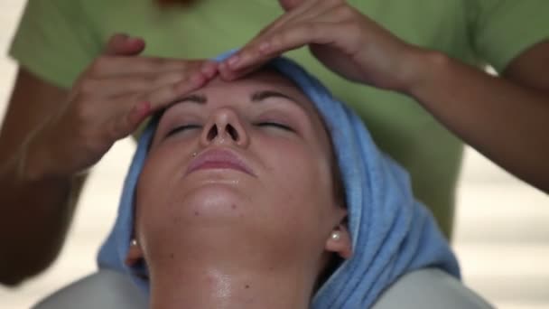 Крупный план массажа женского лица смазанными маслом руками — стоковое видео
