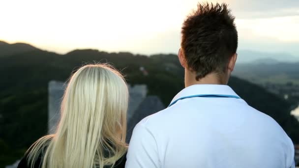 Hombre mostrando chica alrededor de un castillo romántico vista — Vídeo de stock