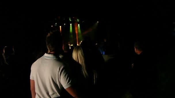 Широкий снимок молодой пары, наслаждающейся музыкой на концерте — стоковое видео