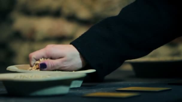 Женщина проверяет сушеную пшеницу в маленьких тарелках — стоковое видео
