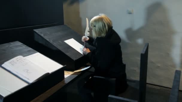 Kvinnan skriver i slottet gästbok med fjäder penna — Stockvideo