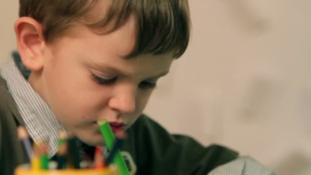 Junges Kind zeichnet mit grünen Buntstiften — Stockvideo