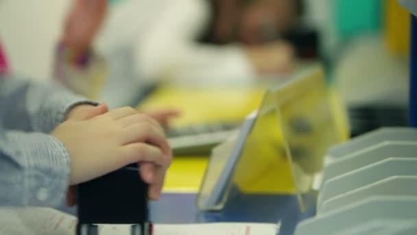 Joven niño sellando documento detrás de la ventana del banco — Vídeo de stock