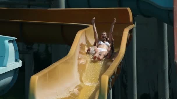 Young couple going down the waterslide — Stock Video