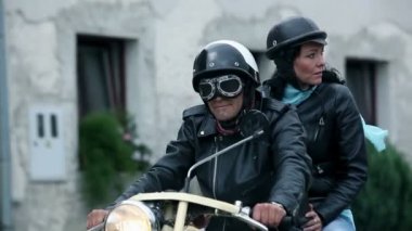 Orta yaşlı çift eski motosiklet sürüş kasabanın içinden aşağıdaki