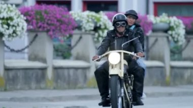 erkek ve kadın kasabanın içinden retro motosiklet sürüş