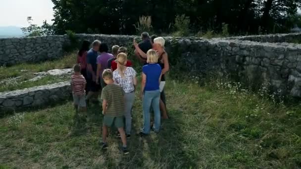 Dolly disparo de turistas grupo disfrutando del viaje de senderismo en ruinas antiguas — Vídeo de stock