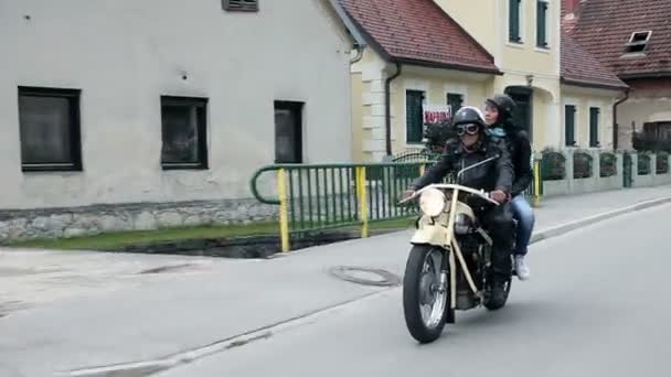 Par på retro motorcykel körning genom liten stad — Stockvideo