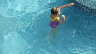 młoda dziewczyna w różowy strój kąpielowy nurkowanie w basenie
