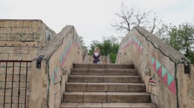 Antik kentin içinde kayalık bir köprü üzerinde çalışan kadın