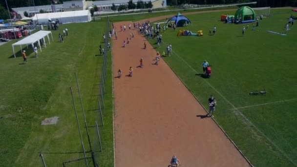 Crianças competindo na corrida de bicicleta tiro do céu — Vídeo de Stock