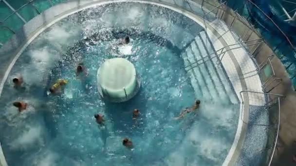 Crane wide shot of people swimming in pool — Stock Video