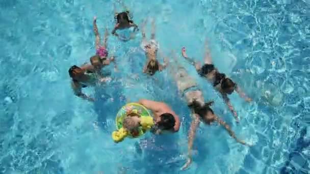 Plan à angle bas à élevé de la famille profitant d'un parc aquatique en été — Video