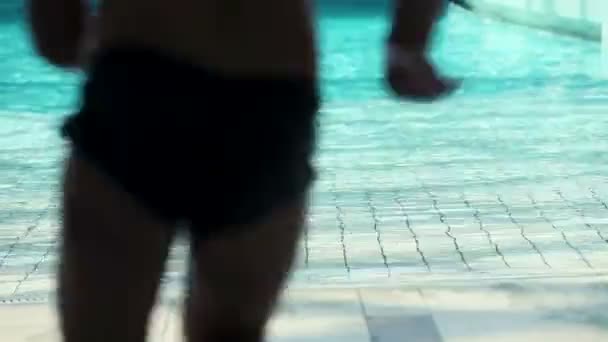 Close up on two girls and boy running into pool water — Stock Video