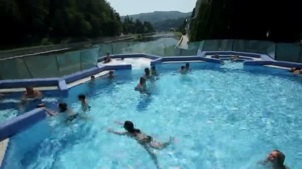 People enjoying time in pool crane shoot — Stock Video