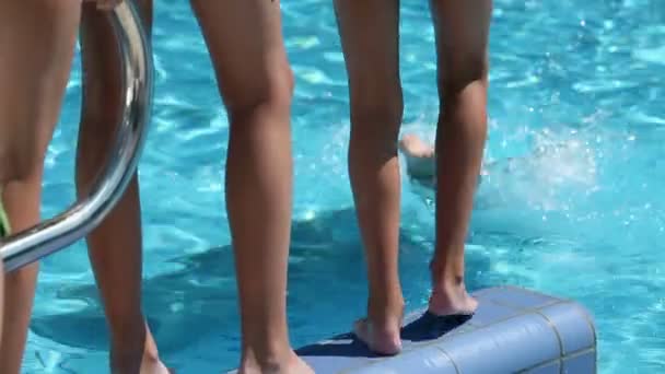 Close up on legs of kids while jumping into pool — Stock Video